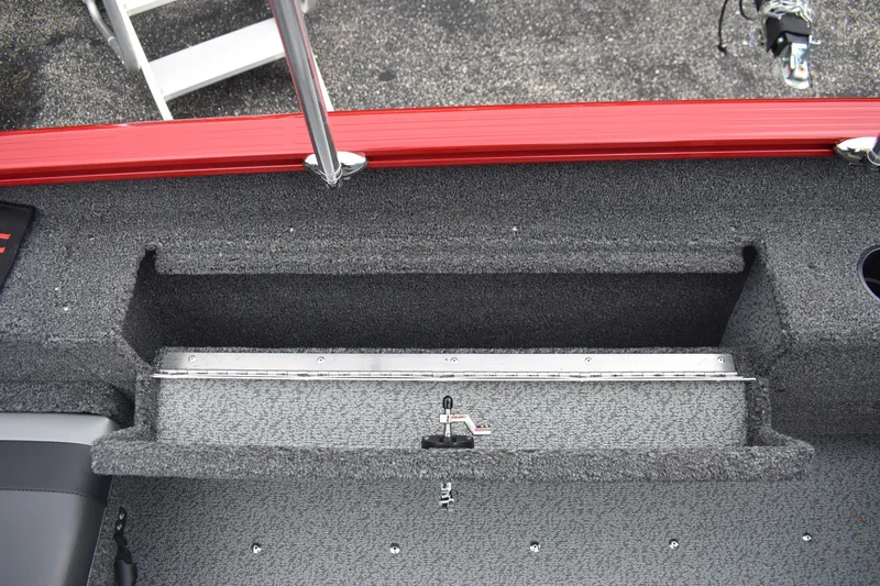 Slide: The Image of 2026 Lund 1775 Adventure Sport boat interior storage compartment with red trim. - 15