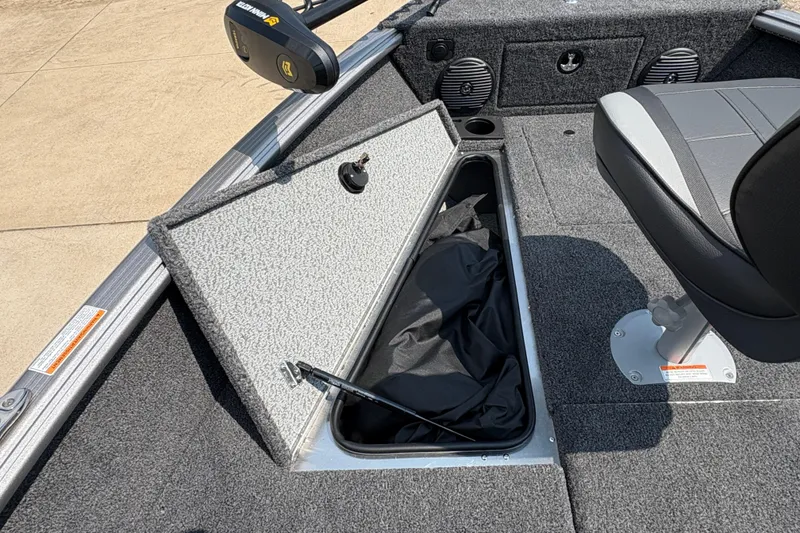 Slide: The Image of 2026 Lund 1875 Impact XS Sport boat interior with open storage compartment and seating. - 12