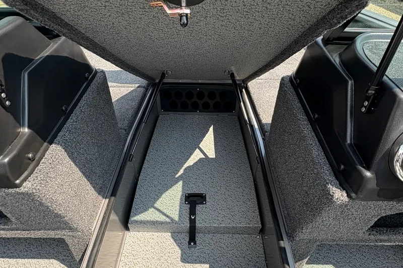 Slide: The Image of 2026 Lund 1875 Impact XS Sport boat interior storage compartment, open and carpeted. - 16