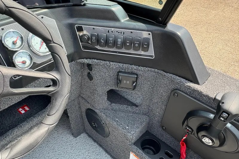 Slide: The Image of Interior dashboard of 2026 Lund 1875 Impact XS Sport boat with steering wheel and controls. - 22