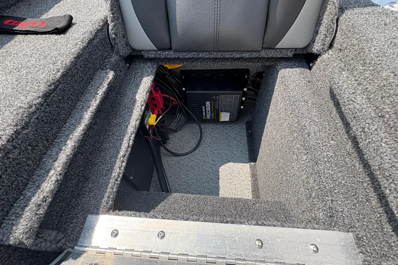 Slide: The Image of 2026 Lund 1875 Impact XS Sport boat interior with battery compartment and charger. - 29