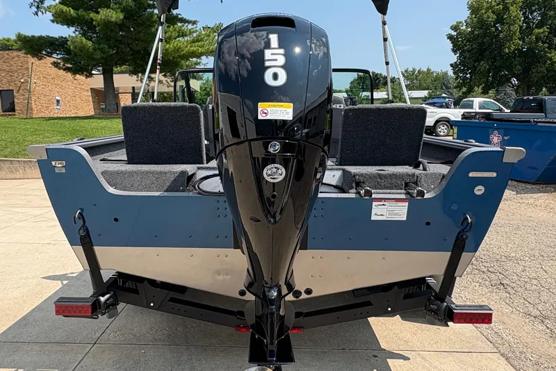 Slide: The Image of 2026 Lund 1875 Impact XS Sport boat with powerful outboard motor, parked outdoors. - 3