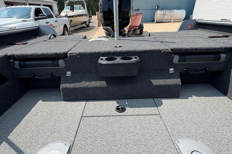 Slide: The Image of 2026 Lund 1875 Impact XS Sport boat interior with storage compartments and cup holders. - 32