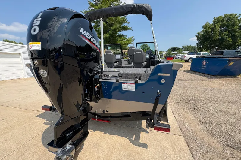 Slide: The Image of 2026 Lund 1875 Impact XS Sport boat with Mercury 150 engine, parked outdoors. - 35