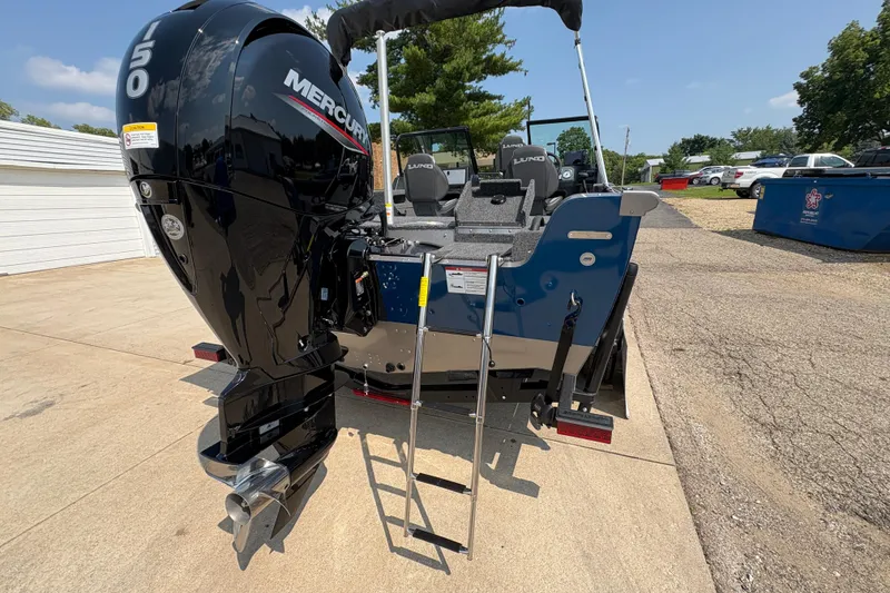 Slide: The Image of 2026 Lund 1875 Impact XS Sport boat with Mercury engine, parked outdoors. - 36