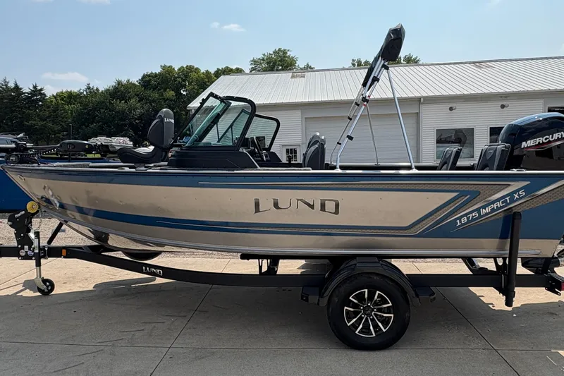 Slide: The Image of 2026 Lund 1875 Impact XS Sport boat on trailer, parked outdoors. - 5
