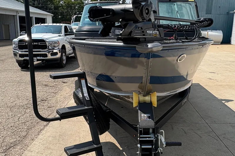 Slide: The Image of 2026 Lund 1875 Impact XS Sport boat on trailer, parked near vehicles. - 7