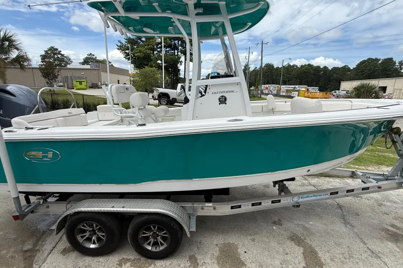Slide: The Image of 2021 Sea Hunt Ultra 219 boat on trailer, teal hull, outdoor setting. - 12