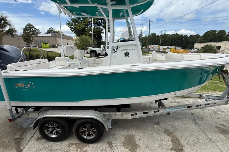 Slide: The Image of 2021 Sea Hunt Ultra 219 boat on trailer, teal hull, outdoor setting. - 13