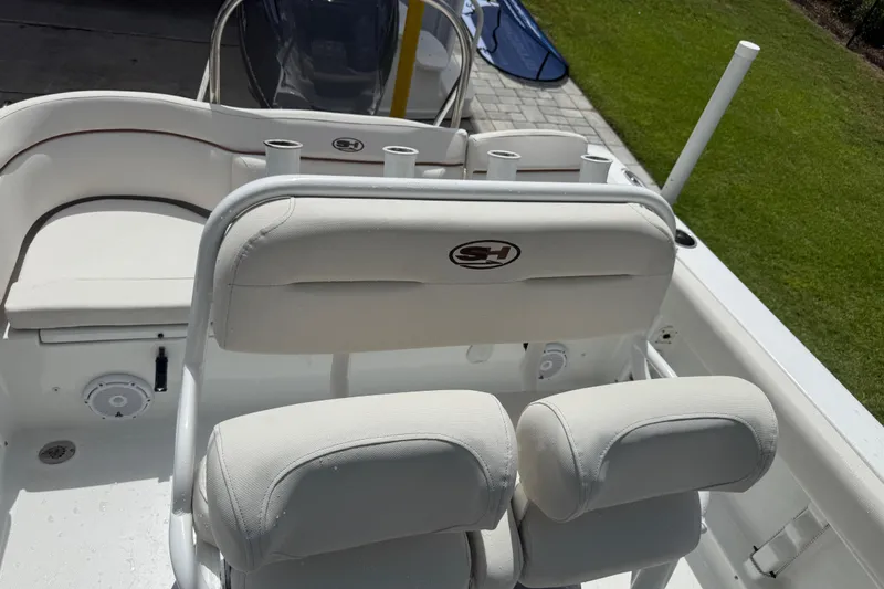 Slide: The Image of 2021 Sea Hunt Ultra 219 boat interior with white seating and rod holders. - 28