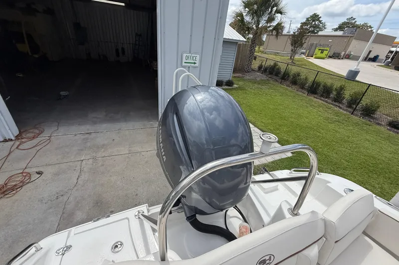 Slide: The Image of 2021 Sea Hunt Ultra 219 boat with Yamaha outboard motor near a garage. - 33