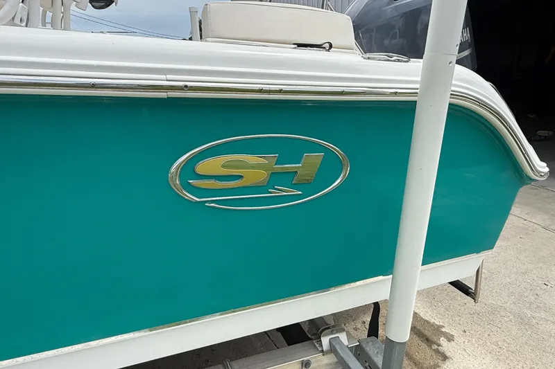 Slide: The Image of 2021 Sea Hunt Ultra 219 boat with teal hull and SH logo. - 5