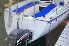 Slide: The Image of 1986 O'Day 272 sailboat docked with blue seating and outboard motor. - 3