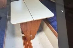 Slide: The Image of 1986 O'Day 272 sailboat interior with foldable table and blue seating. - 5