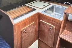 Slide: The Image of 1986 O'Day 272 sailboat interior galley with wooden cabinets and sink. - 6