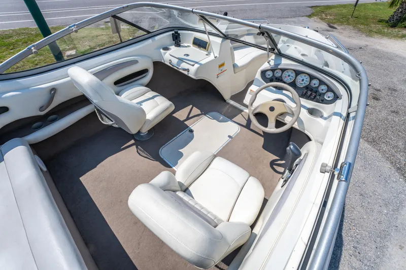Slide: The Image of 2010 Stingray 195LX boat interior with white seating, steering wheel, and dashboard controls. - 13