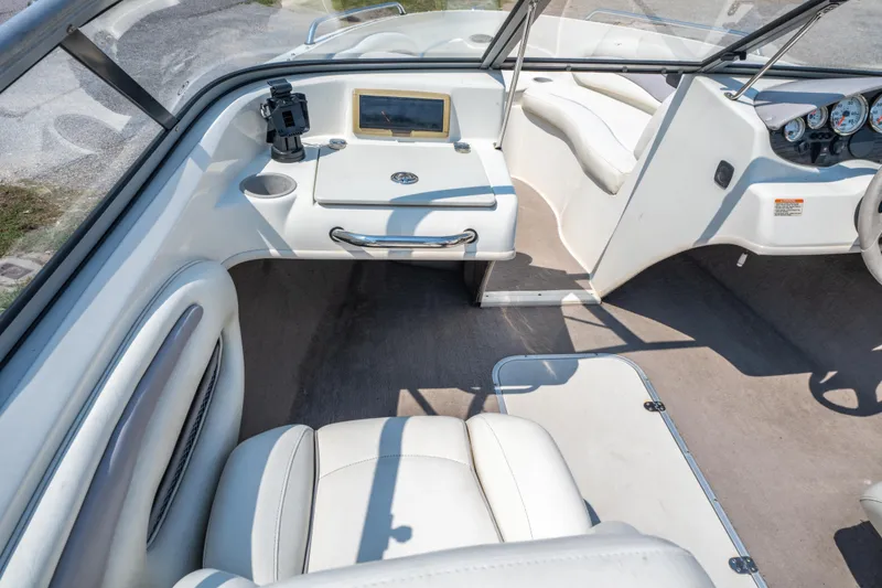 Slide: The Image of Interior of a 2010 Stingray 195LX boat with white seating and dashboard controls. - 15