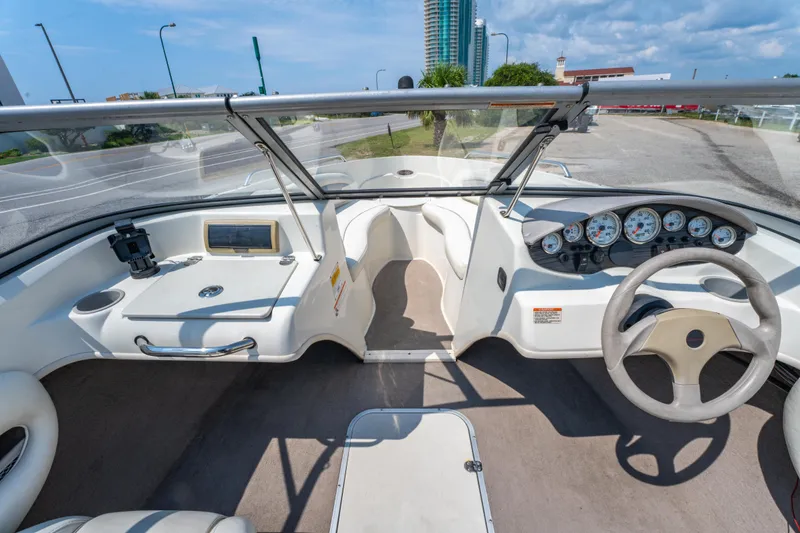 Slide: The Image of 2010 Stingray 195LX boat interior with steering wheel, dashboard, and seating under a clear blue sky. - 16