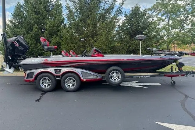 Slide: The Image of 2019 Ranger Z521L boat on trailer, parked outdoors, with trees in the background. - 3