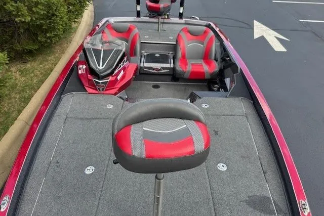 Slide: The Image of 2019 Ranger Z521L boat interior with red and gray seating, parked on pavement. - 5