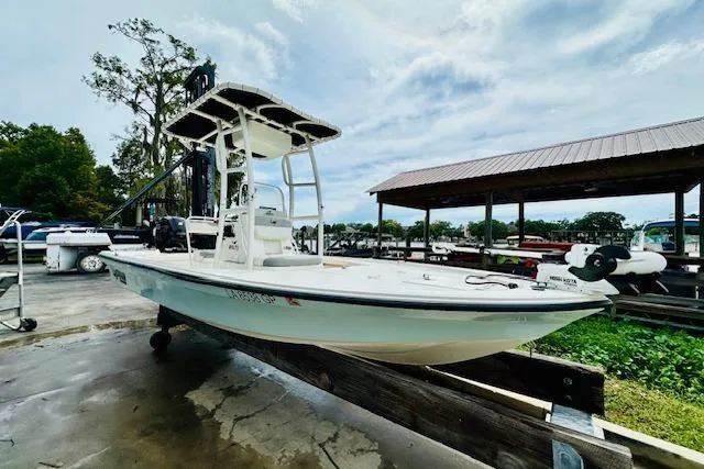 Slide: The Image of 2023 Mako 18 LTS boat docked at a marina under a cloudy sky. - 10