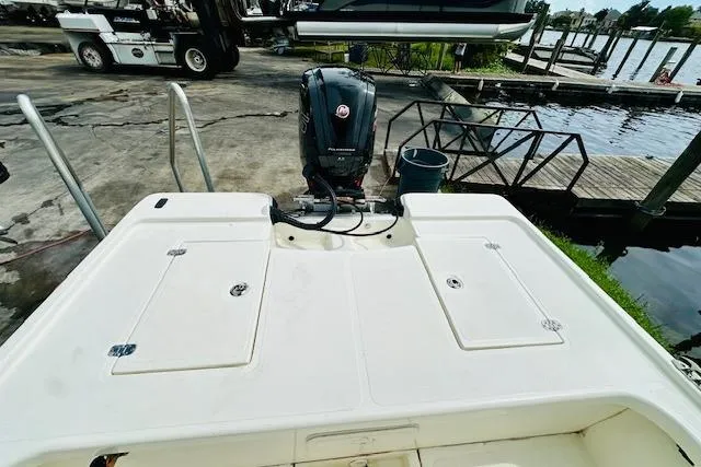 Slide: The Image of 2023 Mako 18 LTS boat with outboard motor at a dockside location. - 11