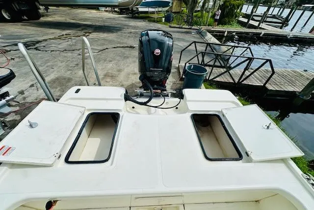 Slide: The Image of 2023 Mako 18 LTS boat with open storage compartments and outboard motor. - 12