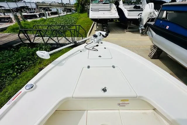 Slide: The Image of 2023 Mako 18 LTS boat at marina, featuring spacious deck and modern design. - 18