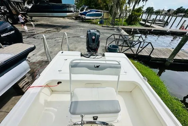 Slide: The Image of 2023 Mako 18 LTS boat at dock, featuring a spacious deck and outboard motor. - 23