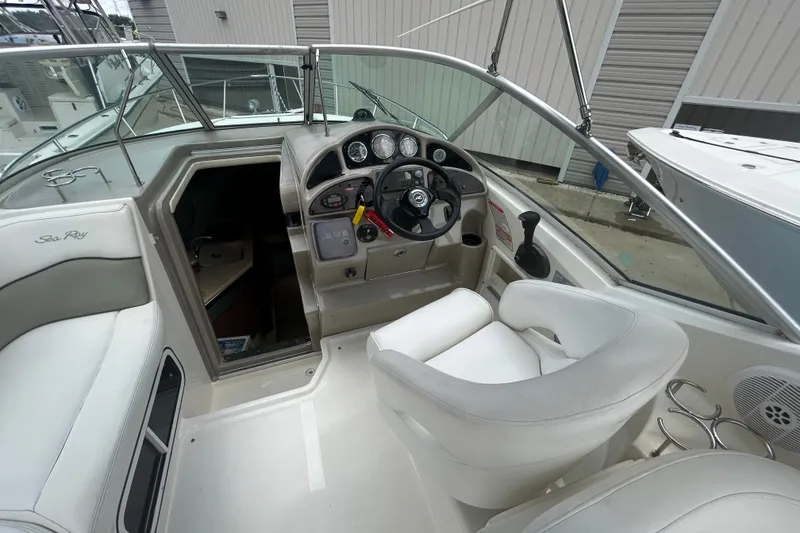 Slide: The Image of 2005 Sea Ray 260 Sundancer boat cockpit with steering wheel and seating area. - 11