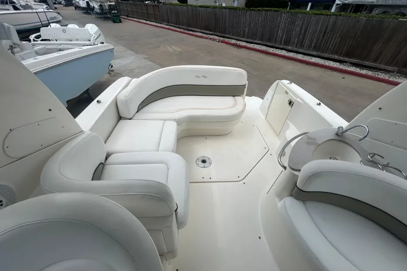 Slide: The Image of 2005 Sea Ray 260 Sundancer boat interior with white seating and compact kitchenette. - 13