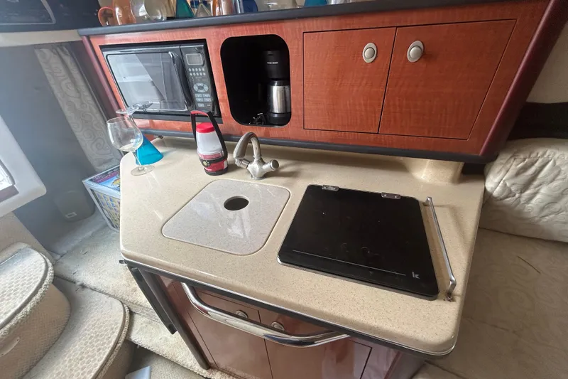 Slide: The Image of 2005 Sea Ray 260 Sundancer cabin kitchen with microwave, sink, and countertop. - 16