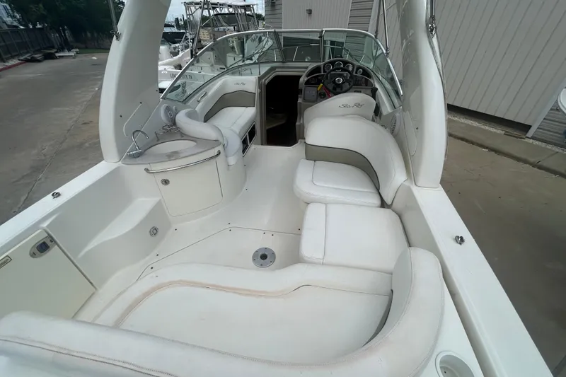 Slide: The Image of 2005 Sea Ray 260 Sundancer boat interior with white seating and helm. - 8