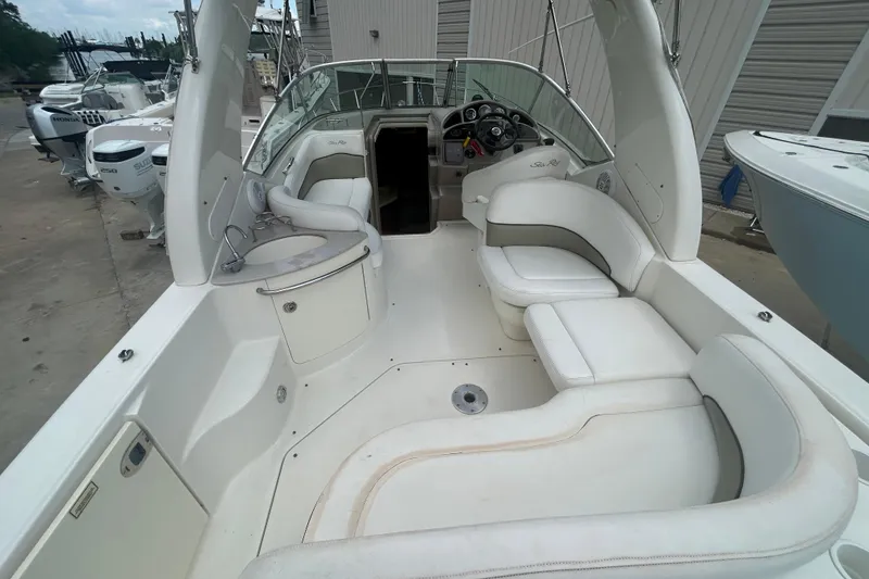 Slide: The Image of 2005 Sea Ray 260 Sundancer boat interior with white seating and helm. - 9
