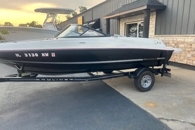Slide: The Image of 2016 Bayliner 175 Bowrider boat on trailer, parked outside a building. - 0