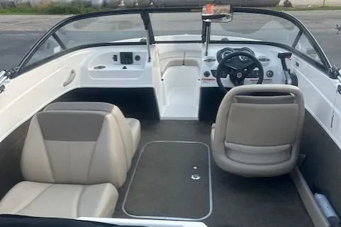 Slide: The Image of 2016 Bayliner 175 Bowrider interior with beige seats and steering wheel. - 2