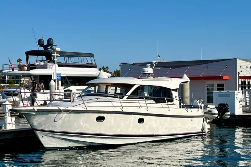 Slide: The Image of 2018 Nimbus 365 Coupe yacht docked at marina under clear blue sky. - 3