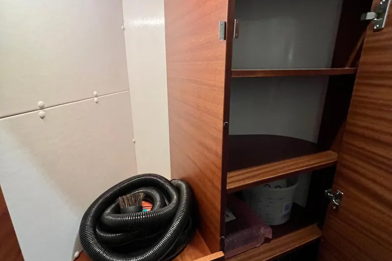 Slide: The Image of Interior storage space of 2018 Nimbus 365 Coupe with wooden shelves and coiled hose. - 151
