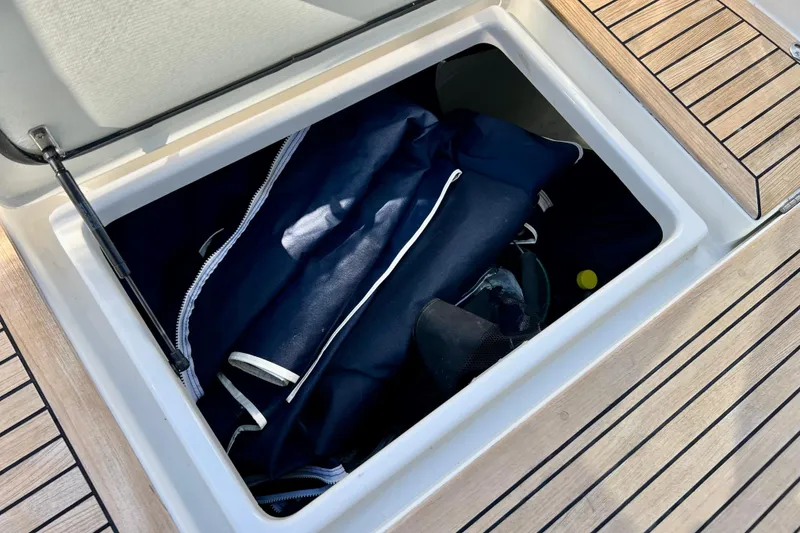 Slide: The Image of Storage compartment on 2018 Nimbus 365 Coupe boat with blue bag inside. - 50
