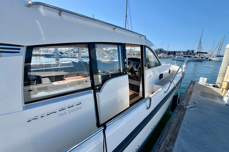 Slide: The Image of 2018 Nimbus 365 Coupe docked at marina, showcasing sleek design and open cabin. - 9