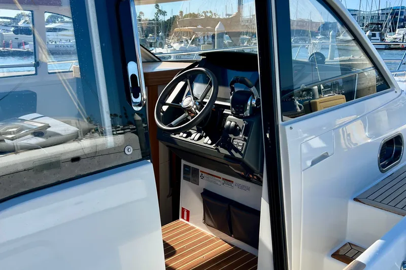 Slide: The Image of Interior view of 2018 Nimbus 365 Coupe boat cockpit with steering wheel and controls. - 35