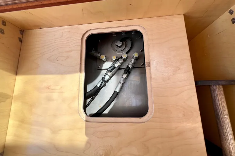 Slide: The Image of Wooden compartment with visible hoses in a 2018 Nimbus 365 Coupe boat. - 118