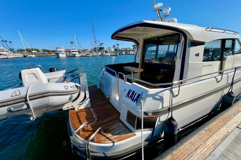Slide: The Image of 2018 Nimbus 365 Coupe yacht docked with inflatable boat, sunny marina setting. - 13