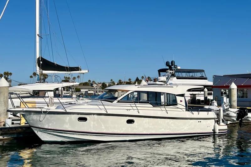 Slide: The Image of 2018 Nimbus 365 Coupe yacht docked at a marina under clear blue skies. - 2