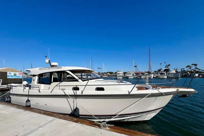 Slide: The Image of 2018 Nimbus 365 Coupe boat docked in a marina under clear blue skies. - 7