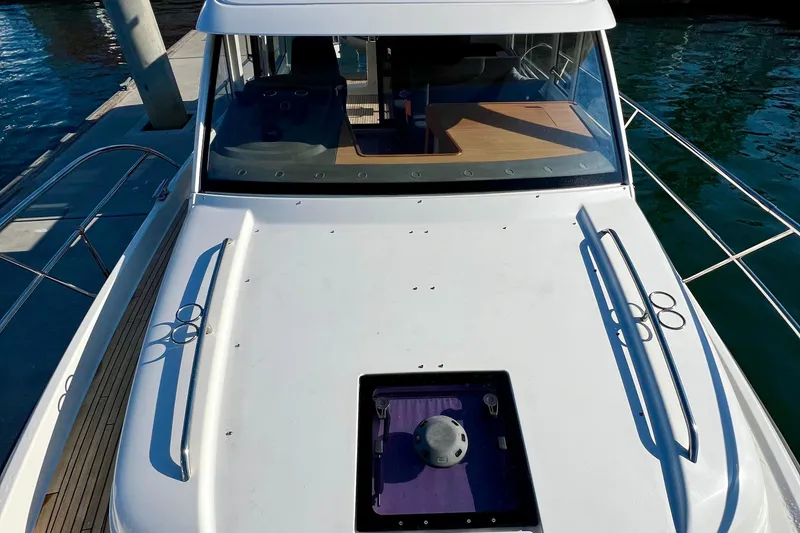 Slide: The Image of 2018 Nimbus 365 Coupe boat docked, showcasing sleek design and spacious deck. - 28