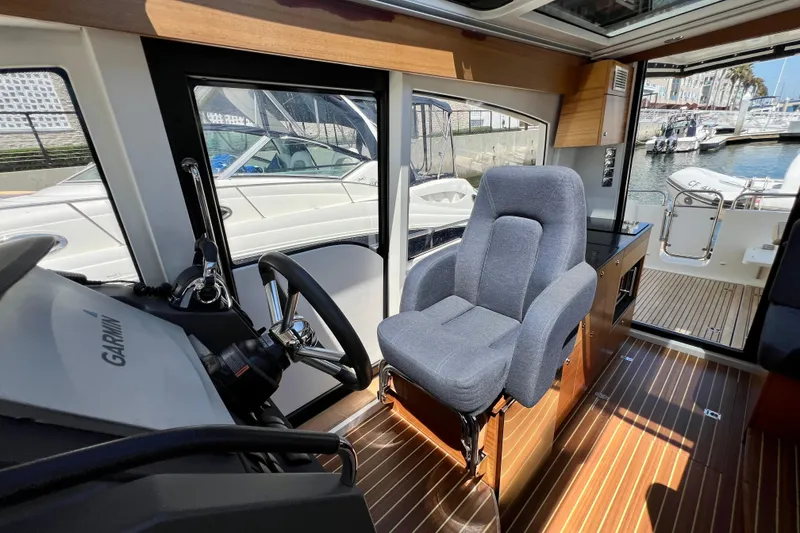 Slide: The Image of Interior of 2018 Nimbus 365 Coupe boat with helm seat and wooden flooring. - 100