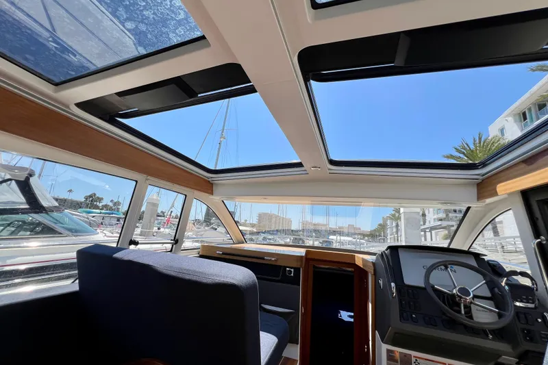 Slide: The Image of Interior view of 2018 Nimbus 365 Coupe boat with sunroof and modern dashboard. - 90