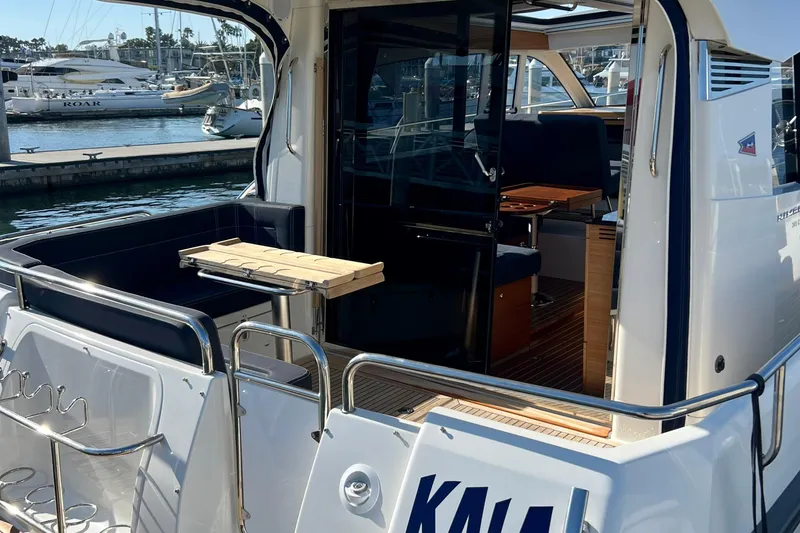 Slide: The Image of 2018 Nimbus 365 Coupe yacht docked, showcasing open deck and interior seating area. - 15
