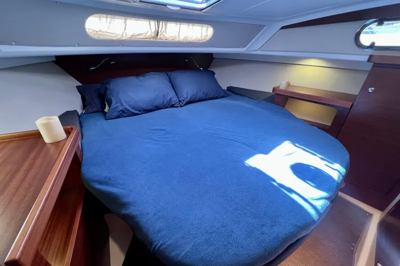 Slide: The Image of Cozy cabin interior of 2018 Nimbus 365 Coupe with blue bedding and wooden accents. - 130